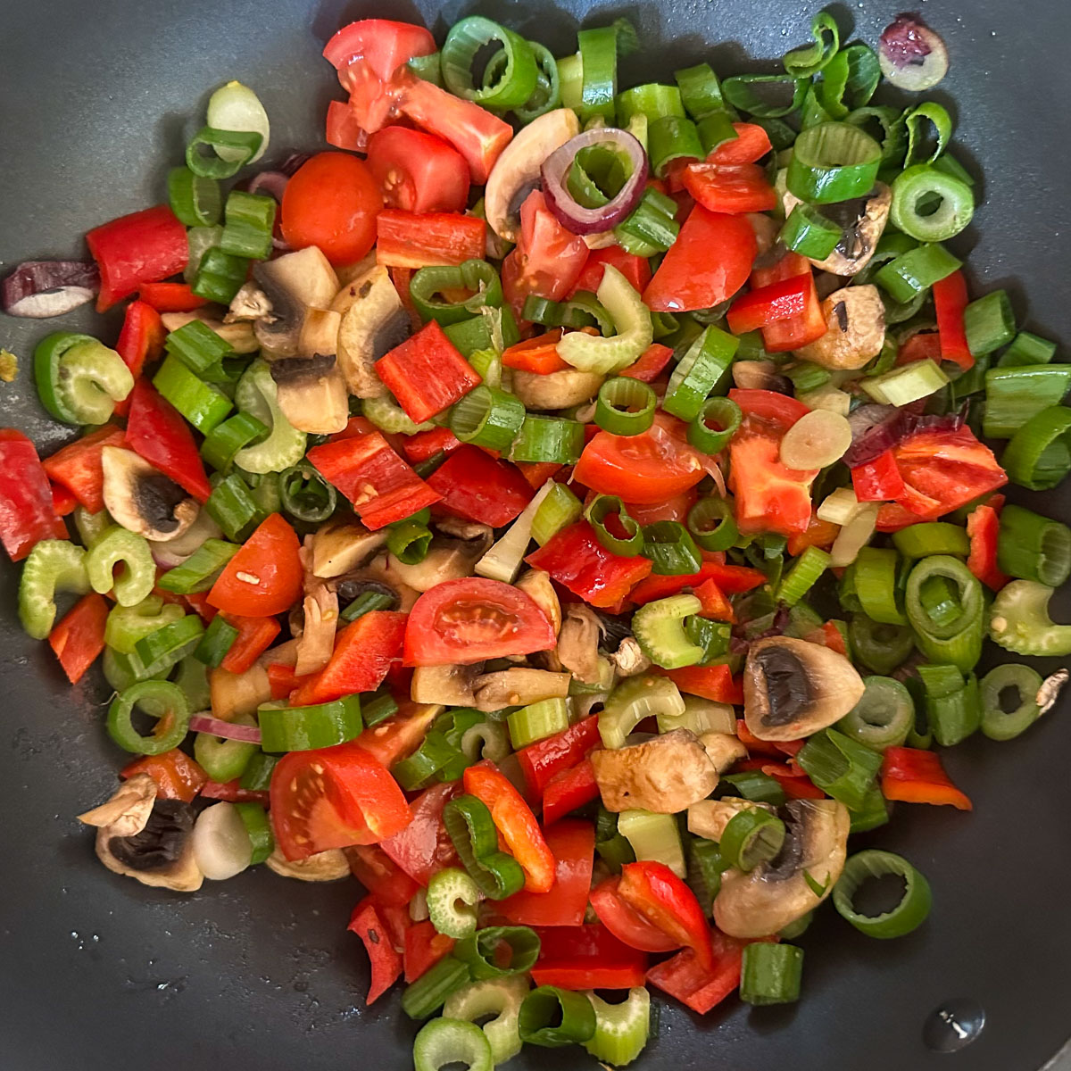 Roerbak van doorgeschoten rode winterui, champignons, paprika, tomaat, en bleekselderij