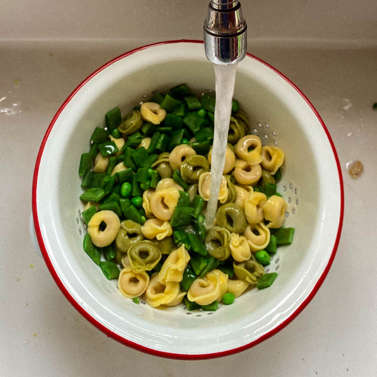 Koel de tortellini en groentes onder koud water af
