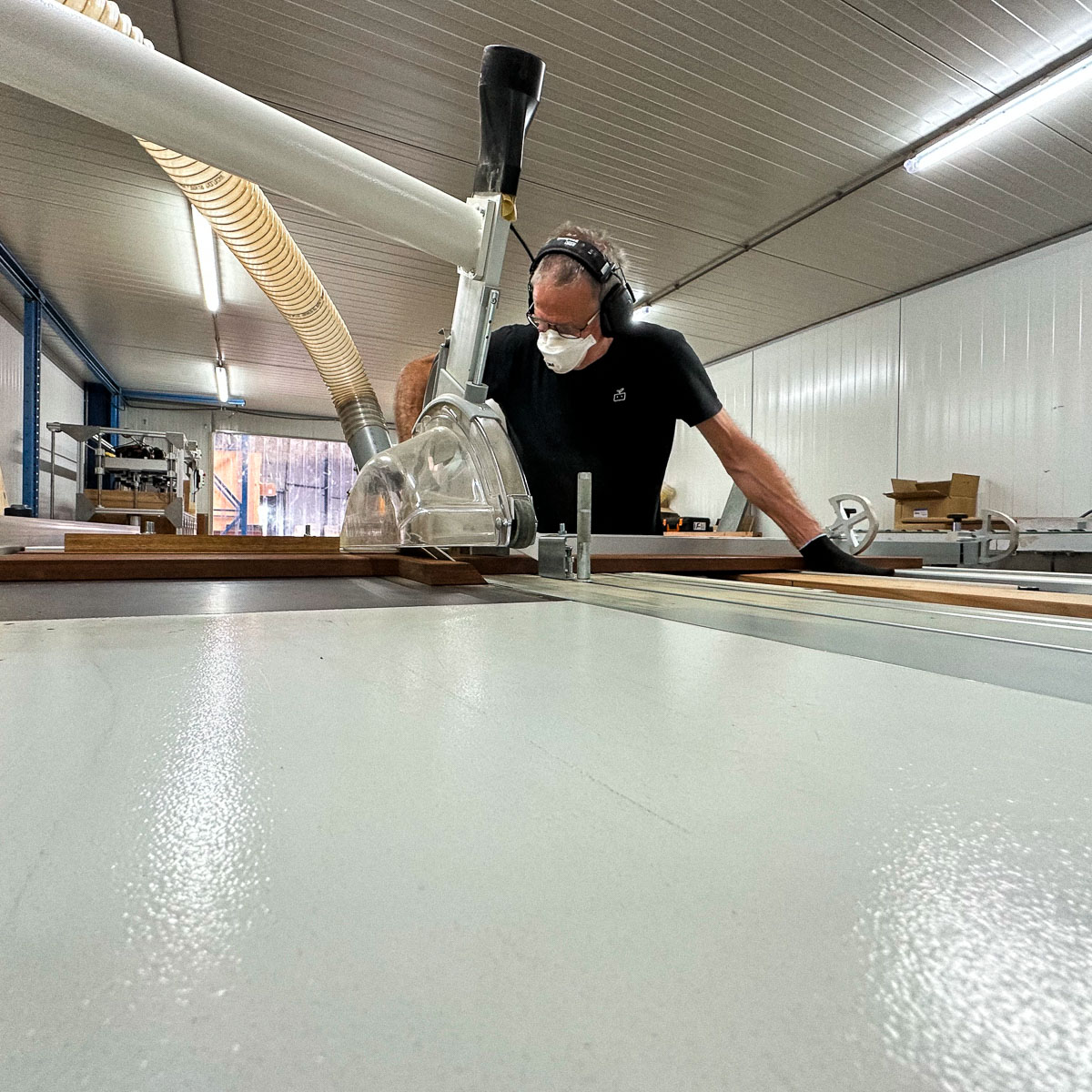 Kees zaagt de planken van de Makkelijke Moestuinbakken van bamboe