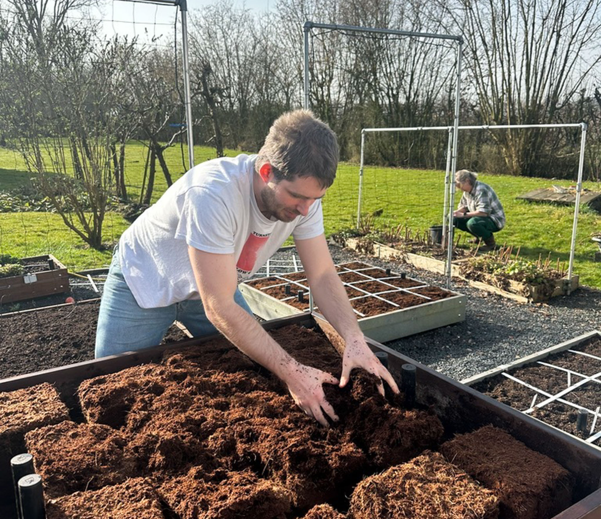Blokken kokosvezels losmaken in een moestuinbak