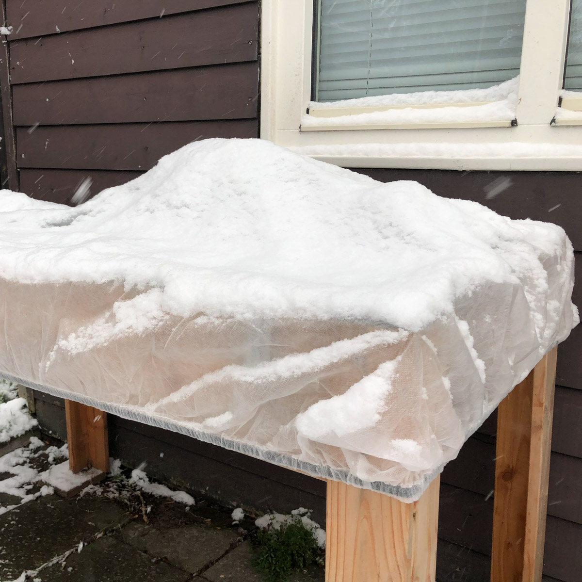 Beschermmuts voor moestuinbak in de sneeuw