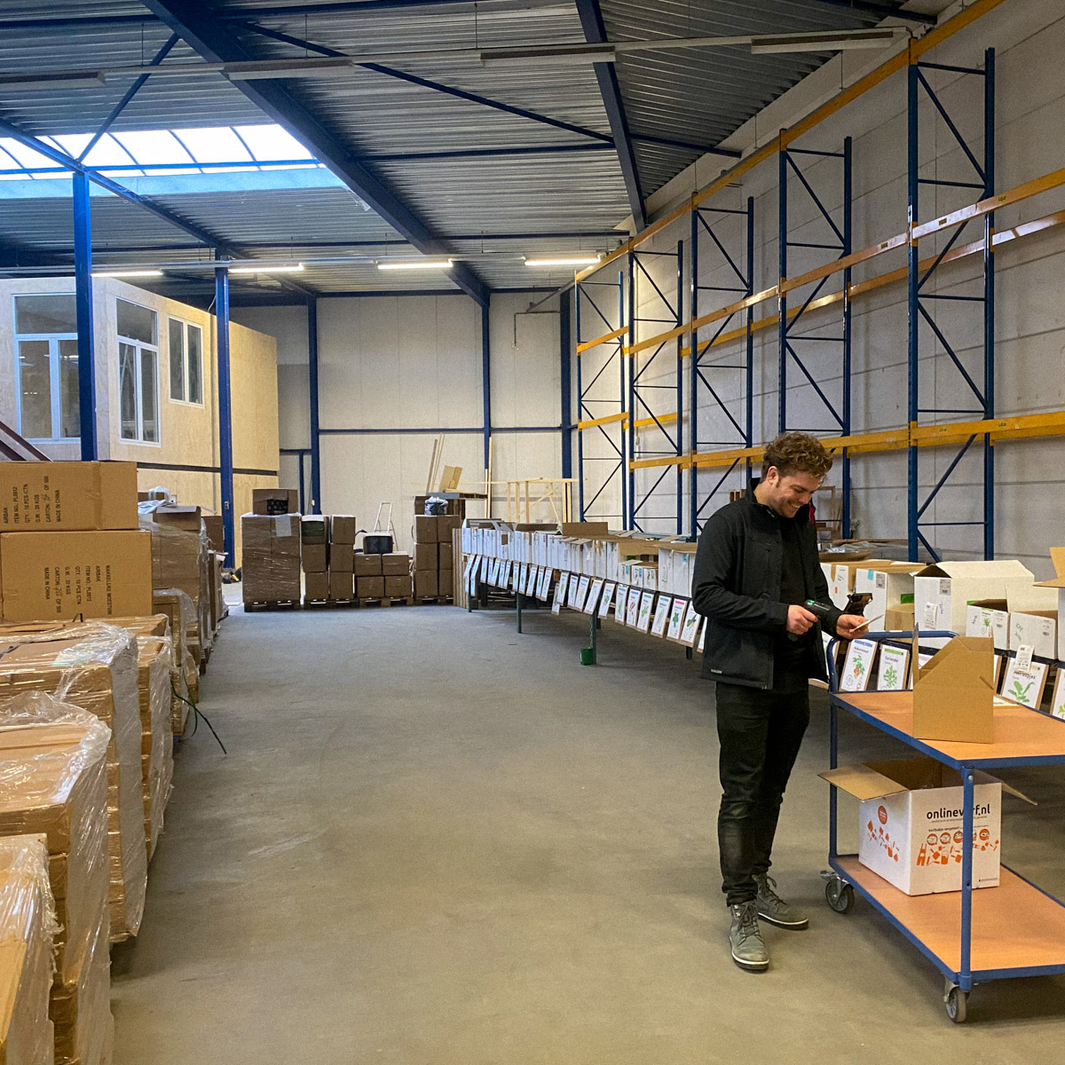 Robbin maakt een order klaar voor verzending in het pakhuis van de Makkelijke Moestuin